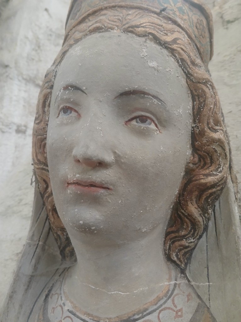 Vue rapprochée du visage de la Vierge avant restauration